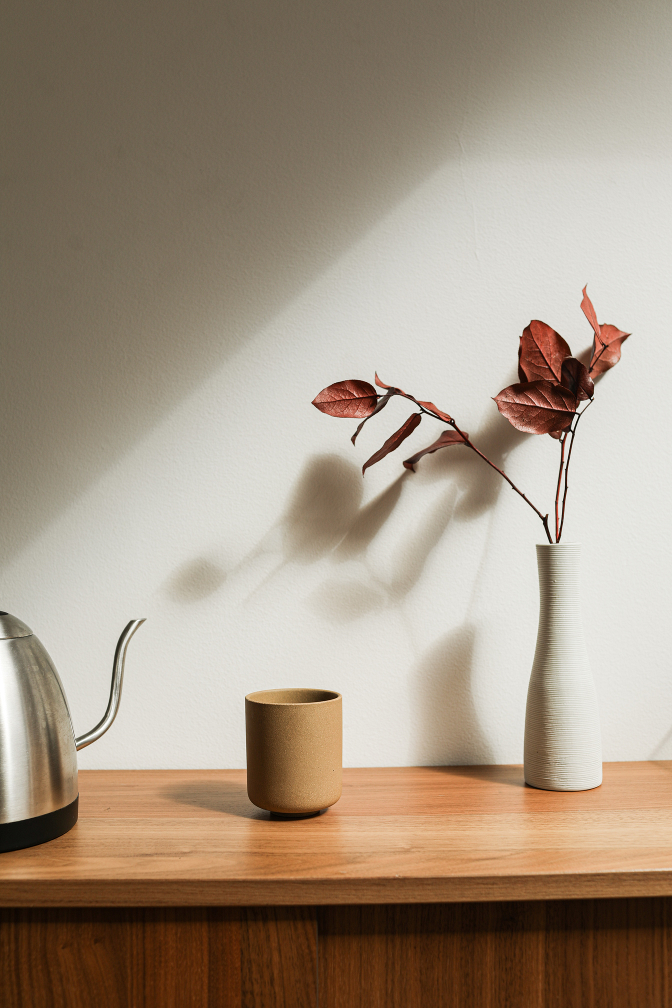 Brown Ceramic Cup Beside White Ceramic Vase